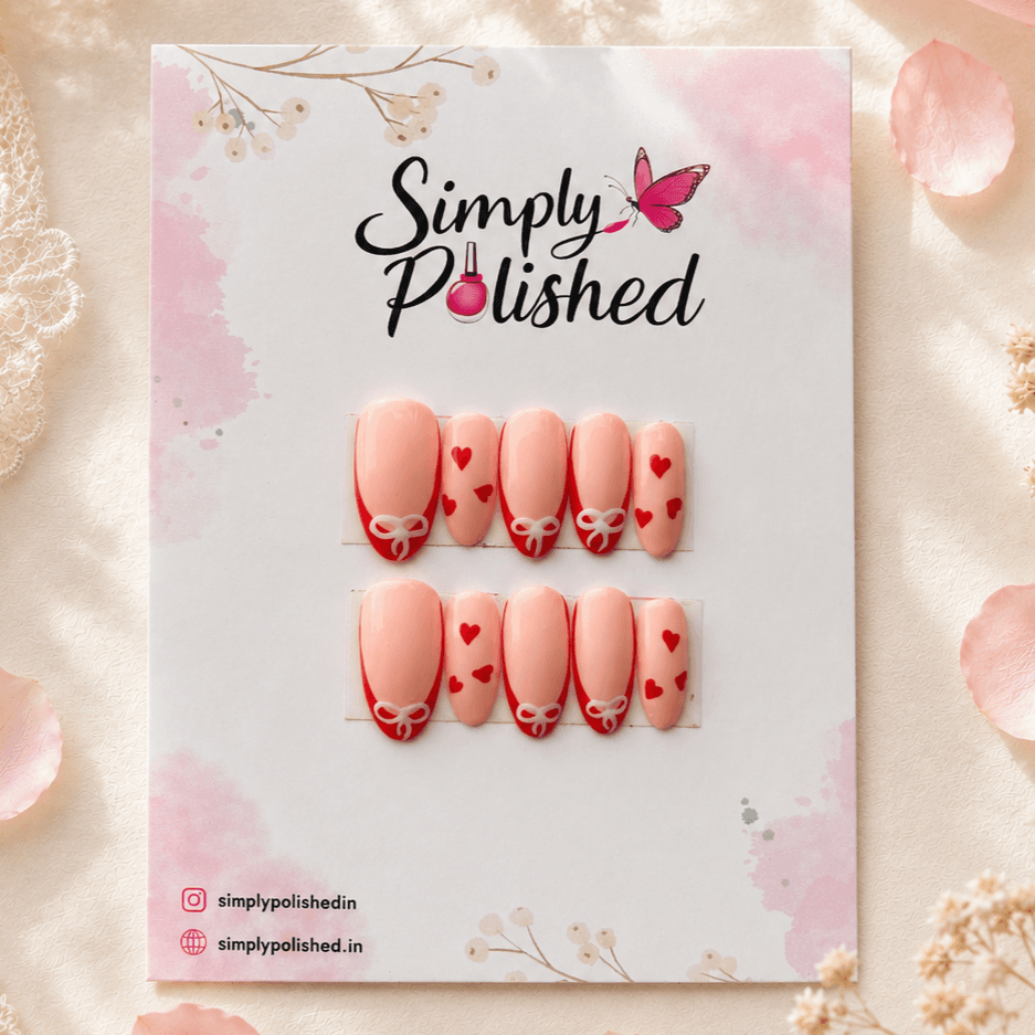 Handcrafted press-on nails with coquette-style bow and heart details on a nude base.