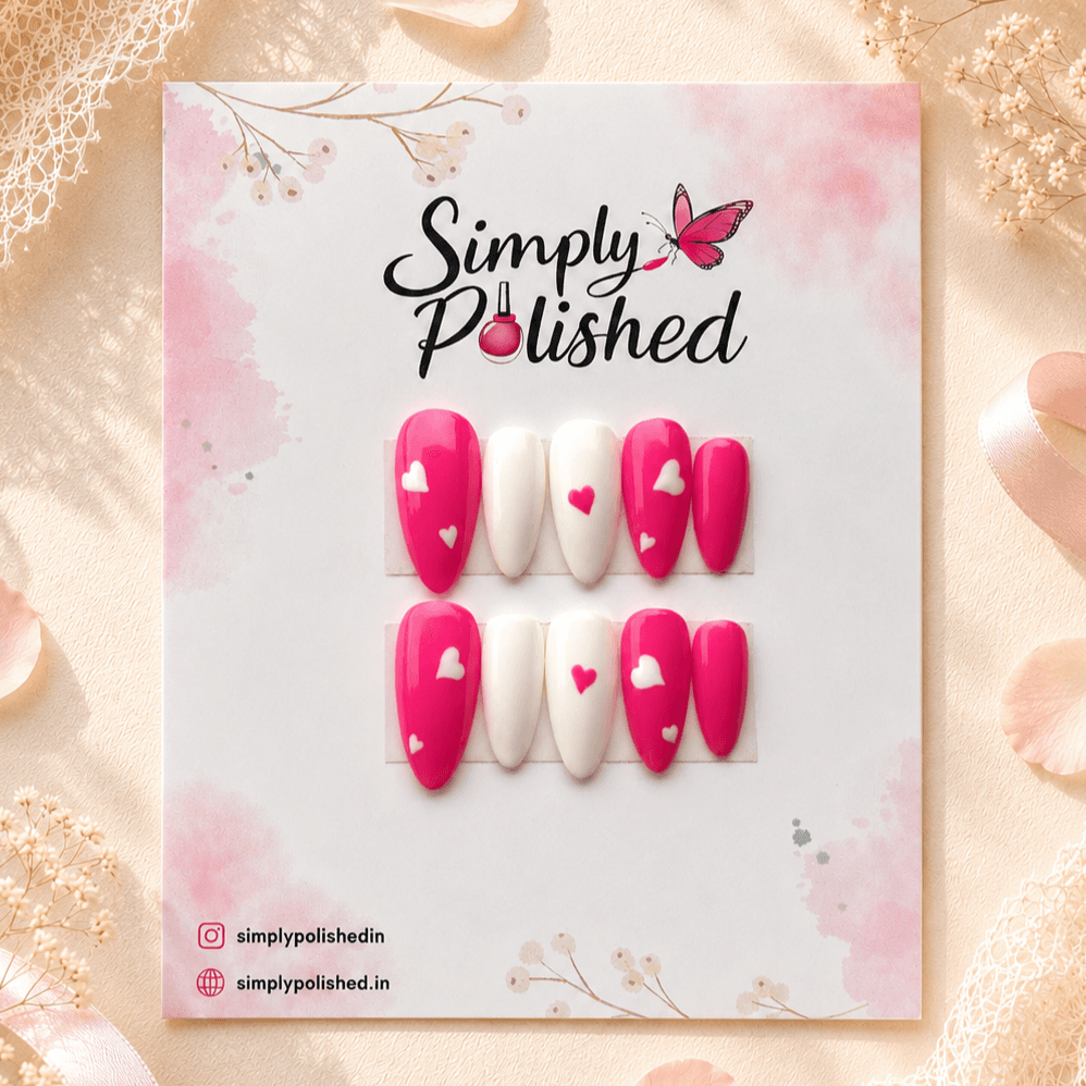 Handcrafted press-on nails with pink heart motifs on a glossy nude base.